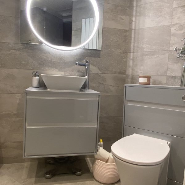 Cloakroom with circular backlit mirror and white WC