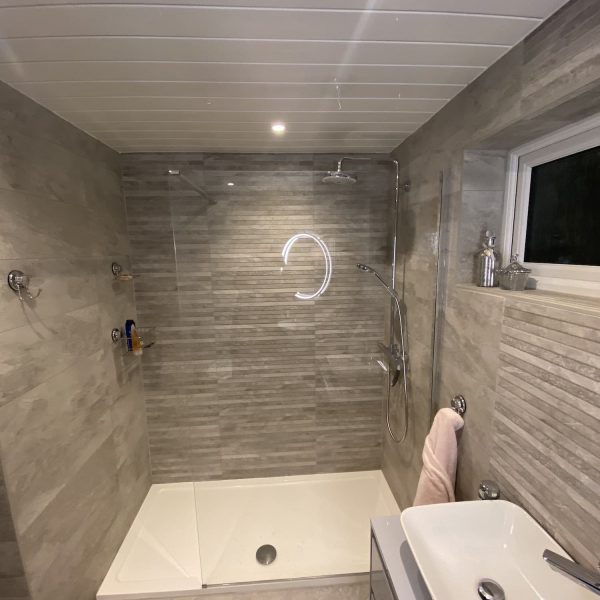 Modern walk in shower with stone tiling