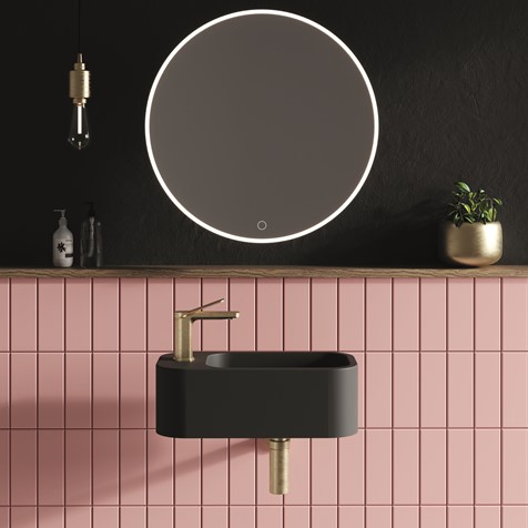 Black sink next to pink tiles